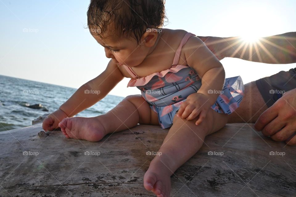 little girl on the trunk at sunset