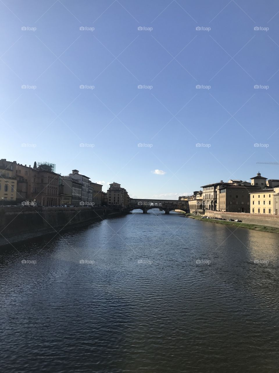 The Ponte Vecchio on the lovely Arno river in Florence, Italy on a beautiful sunny day.