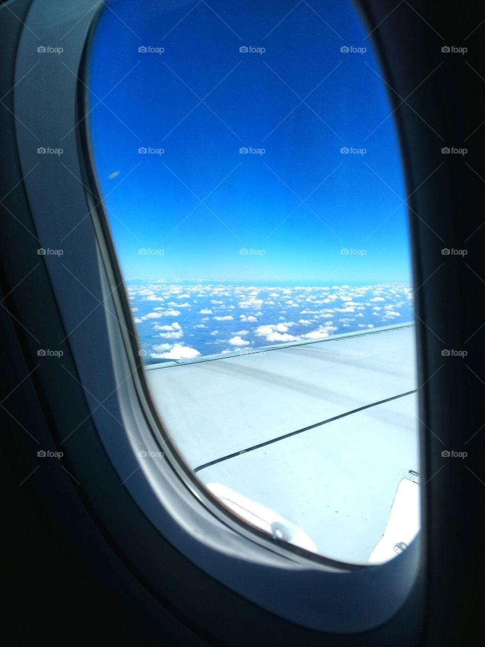 Looking at the sky and clouds through the airplane window.