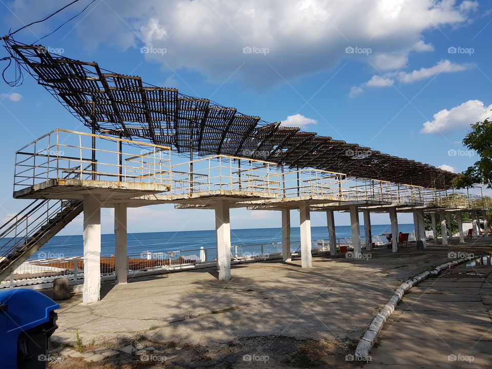 A row of old and abandoned elevated cabins on a beach