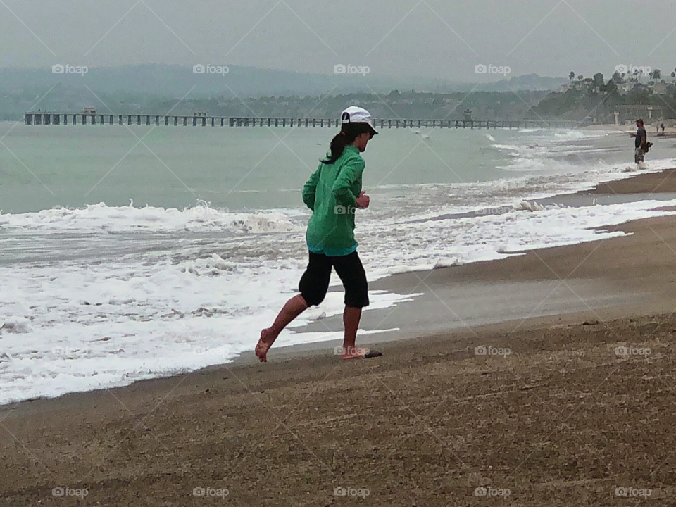 Foap Mission Staying In Good Shape! Woman Running on the Beach On a Cloudy Day