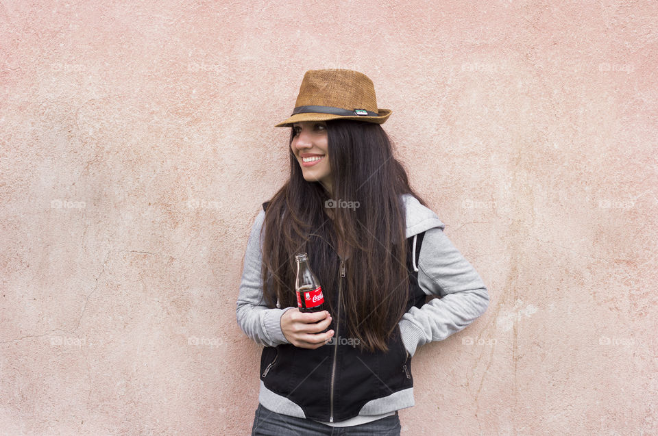 Beautiful woman holds Coca-Cola bottle and smiling