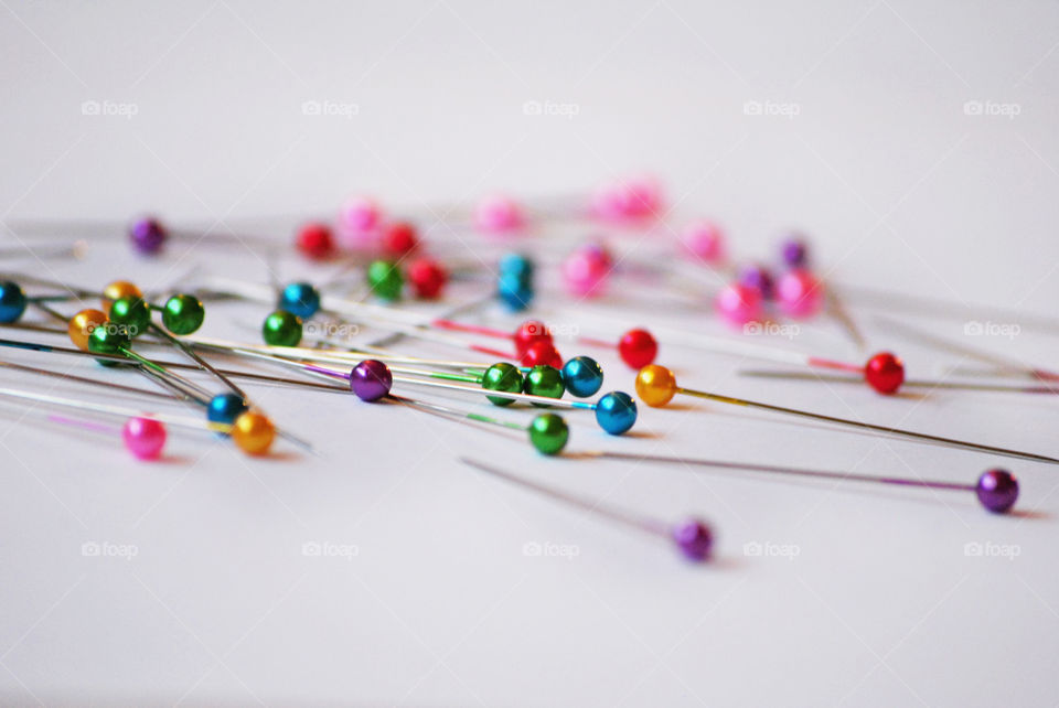 Colorful straight pins on white background