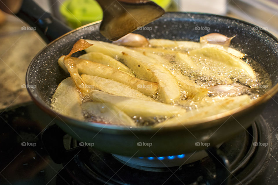 Frying potatoes on a pan with boiling oil