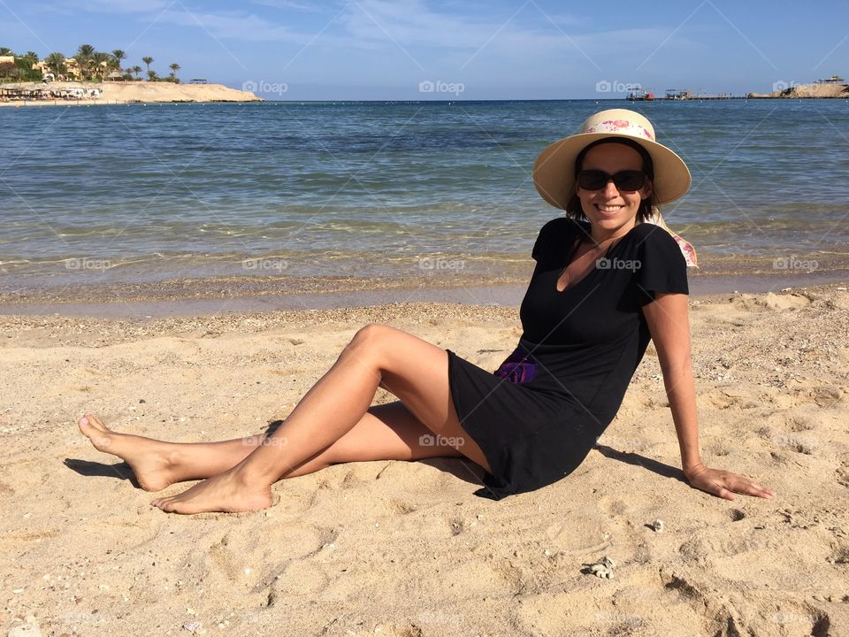 Happy woman sitting on beach