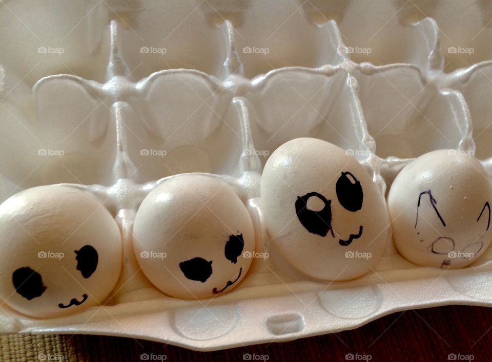 Carton of eggs with faces, drawn by a child