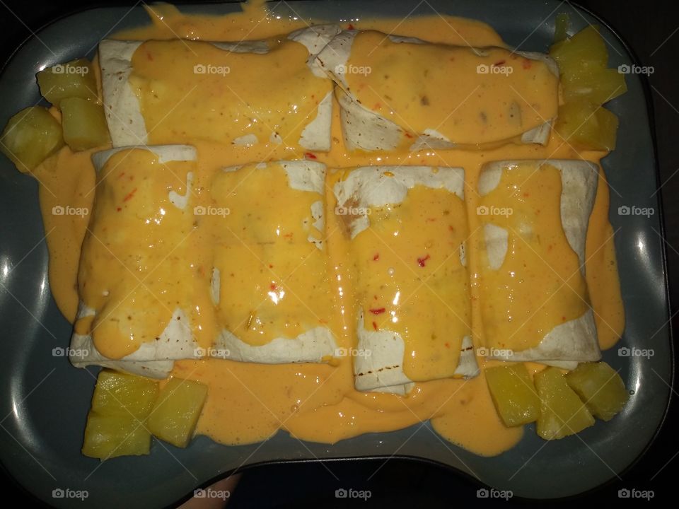 some food I cooked up. turned out delicious. burritos with medium cheese dip as a base. Then a cheese sauce with pineapple mixed into the cheese and lightly baked