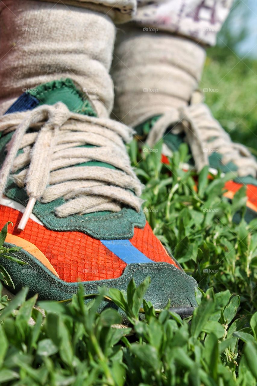 hiking sneakers of a villager and trousers tucked into socks to prevent ticks from crawling under clothes when hiking in the forest with grounding