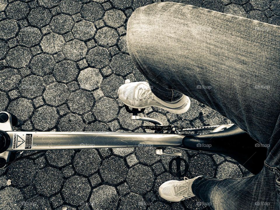 Woman pedaling a bike, view from a bike seat, side view of a bicyclist, looking down on the pedals of a bike, ready to ride the bike, black and white bike photo