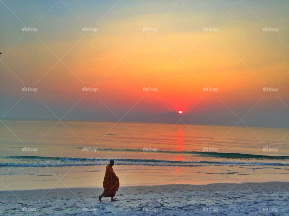 Thai monk on the beach. Thai monk walking on the beach in the morning.