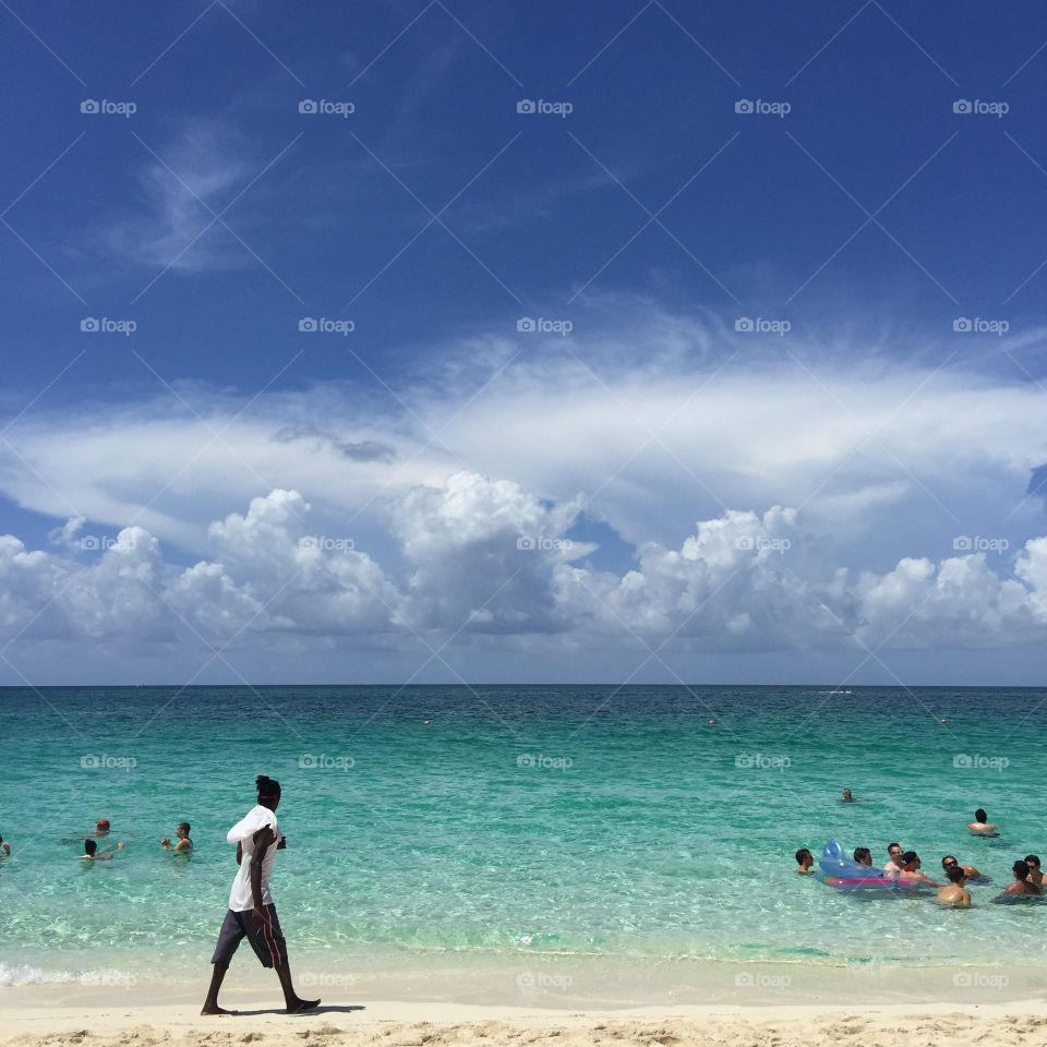 Man walking on the sand 
Blue Ocean 
Bahamas 