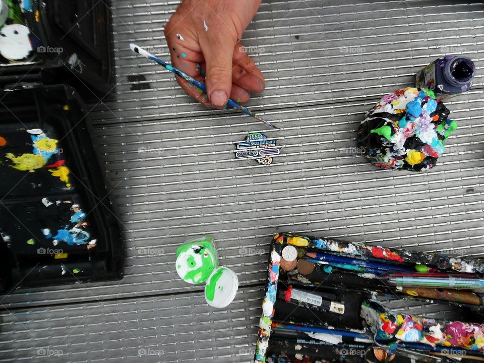 artist finishing art on chewing gum. located on London's millennium bridge the Artist creates tiny works on what was once unsightly mess.