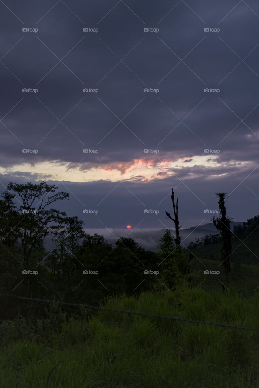 Dark sky with sun on the horizon at time a