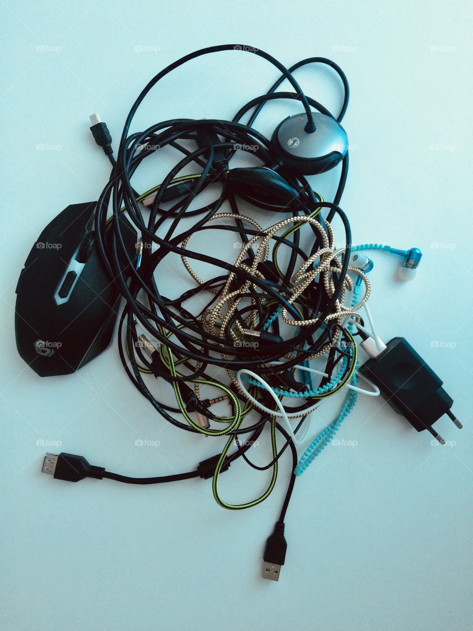 Tangled cables of computer mouse, usb and headphones 