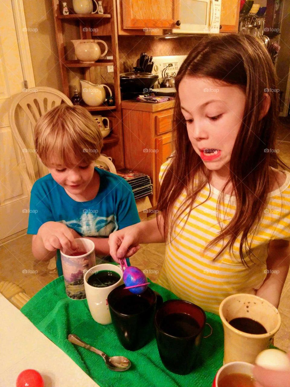 A couple of cousins that are also best friends color eggs for the holiday!