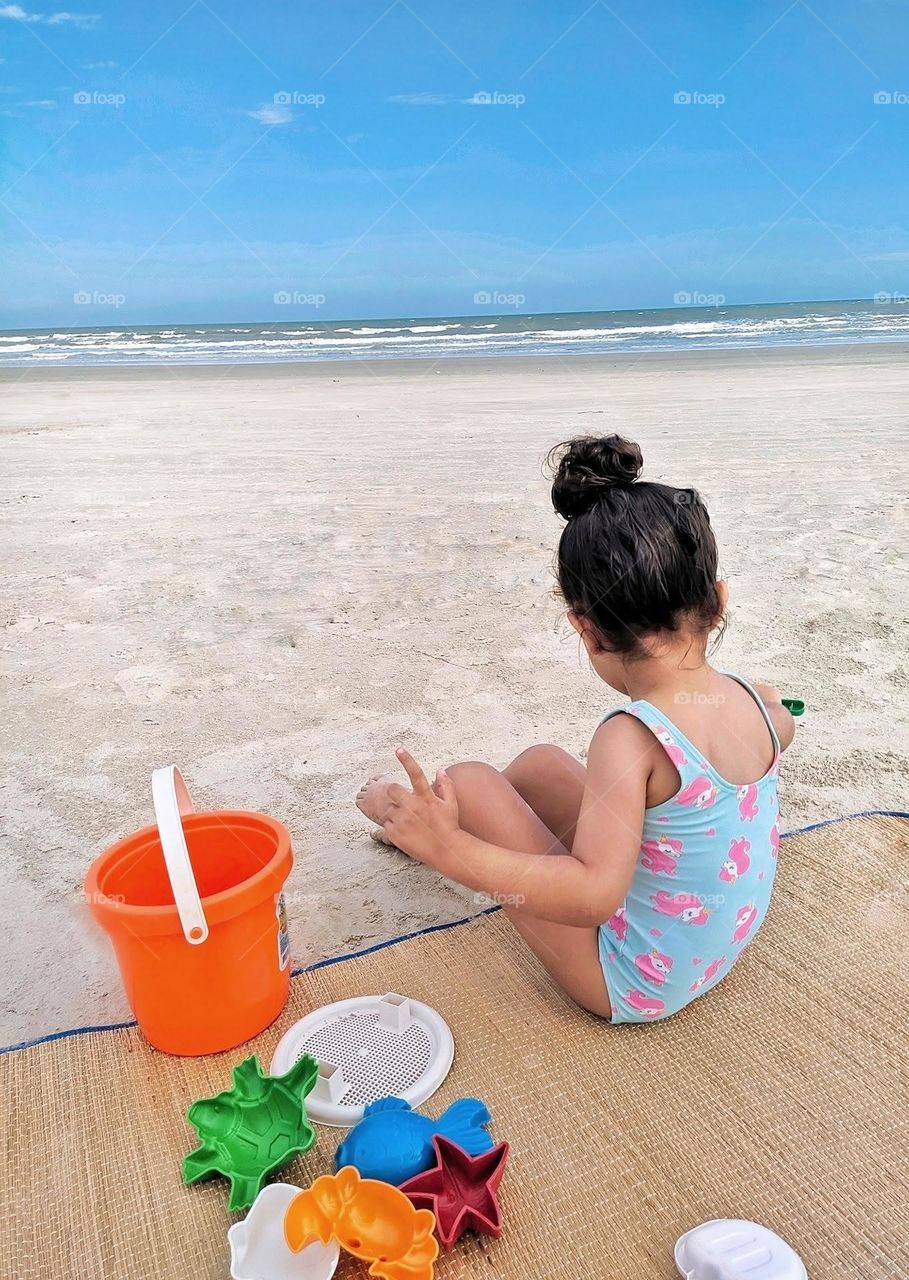 Child playing in the sand on the beach