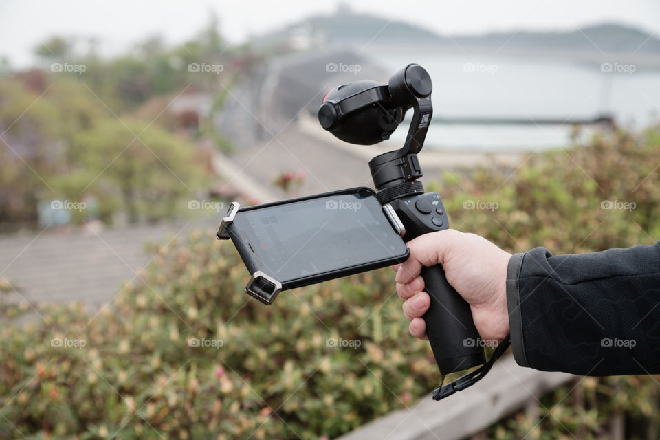 Man hand holding dji osmo for making video