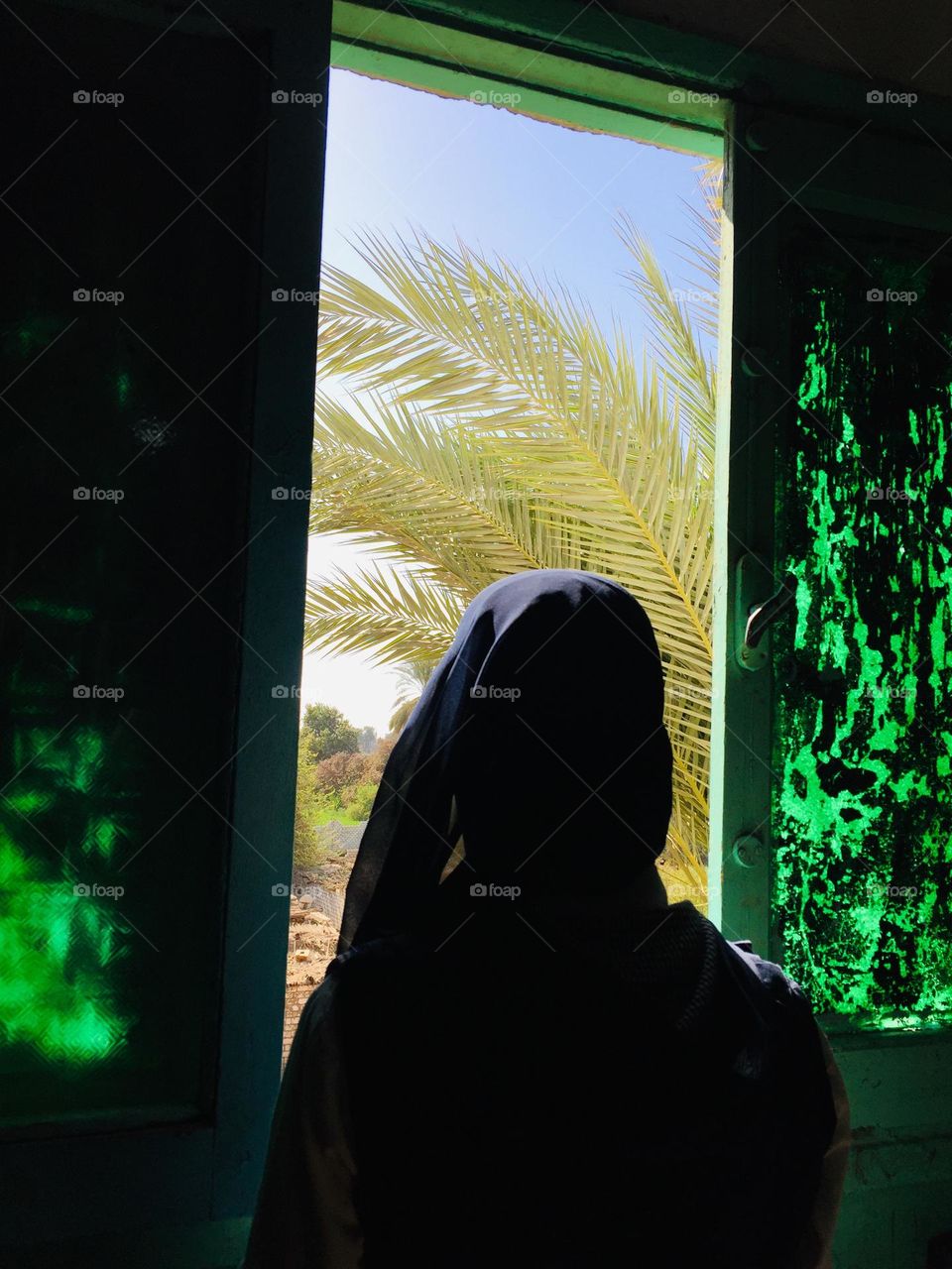 A girl is looking out of a window 