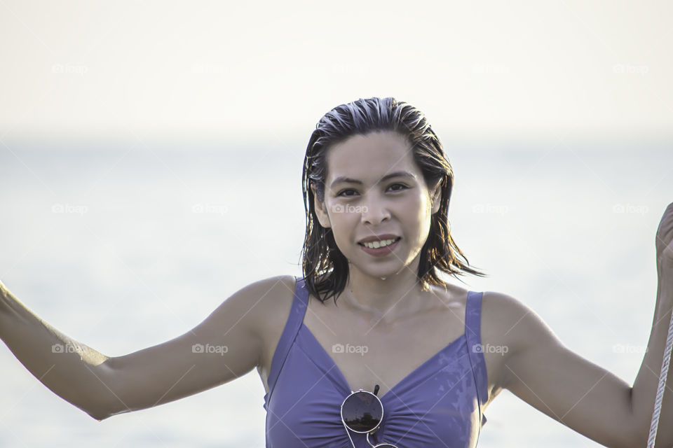 Portrait of Asian woman wearing a swimsuit background sea and sky