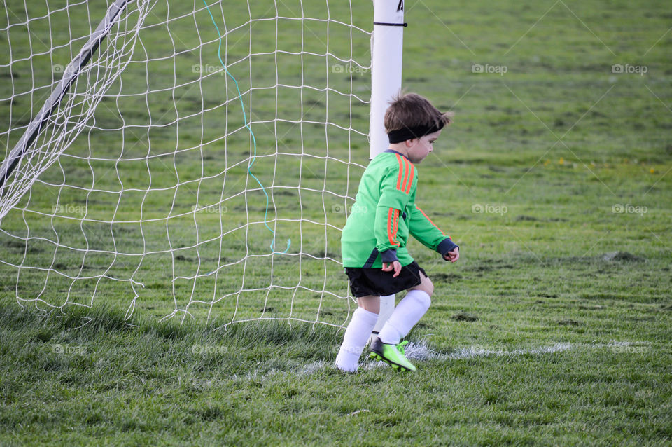 Young boy playing soccer as a goalie