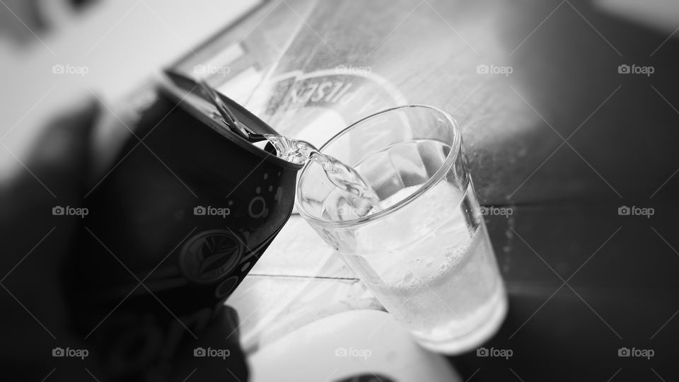 Enchendo o copo com bebida. Latinha, líquido... preto e branco.