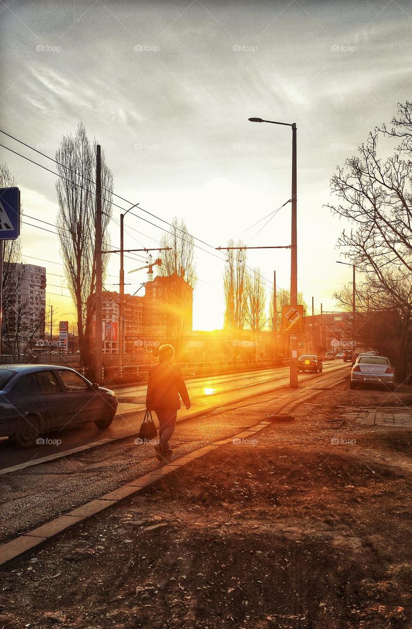 A beautiful morning light photograph of the rising sun in a bulgarian neighbourhood with busy people going to work