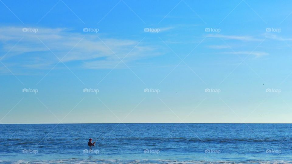 Fisherman at low tide sea