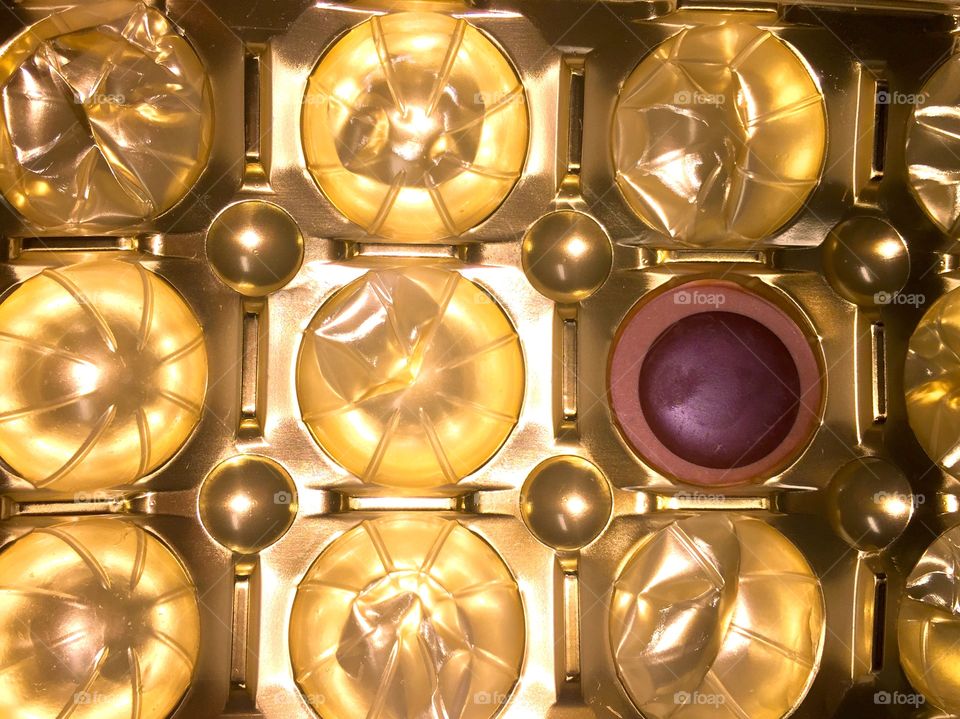 Single piece of chocolate candy in a gold wrapper