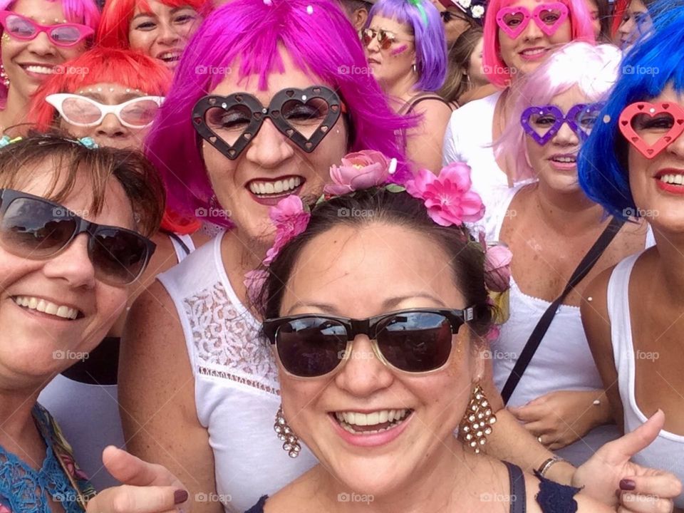 Women in colorful wigs playing street carnival