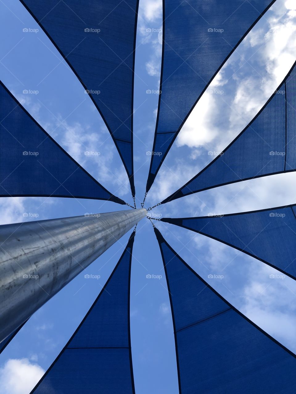 Blue sky with white clouds and blue net and silver pillar
