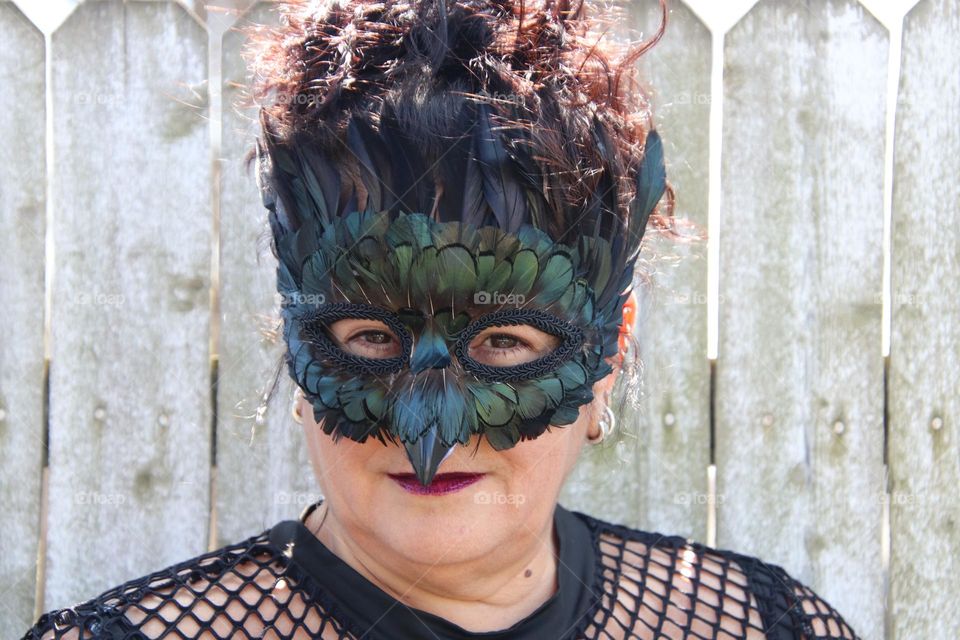 Woman wearing feather masquerade masks