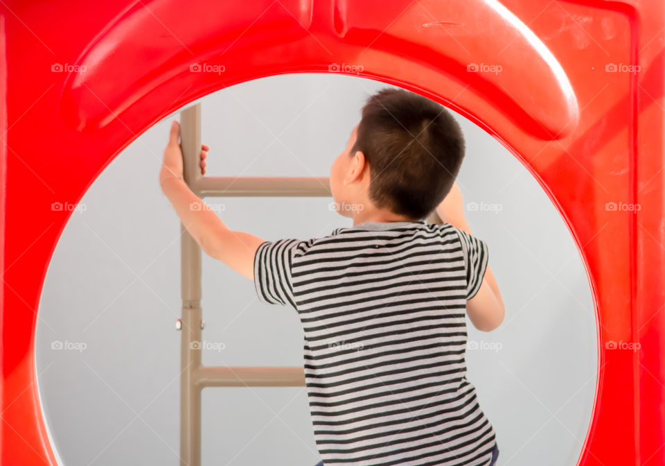 Portrait of Asian boys are climbing the ladder in the playground.