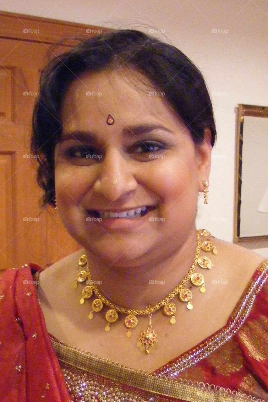 Indian woman preparing for wedding, closeup of woman’s face, decorated for a wedding, Indian woman smiles for camera, portrait of a woman 