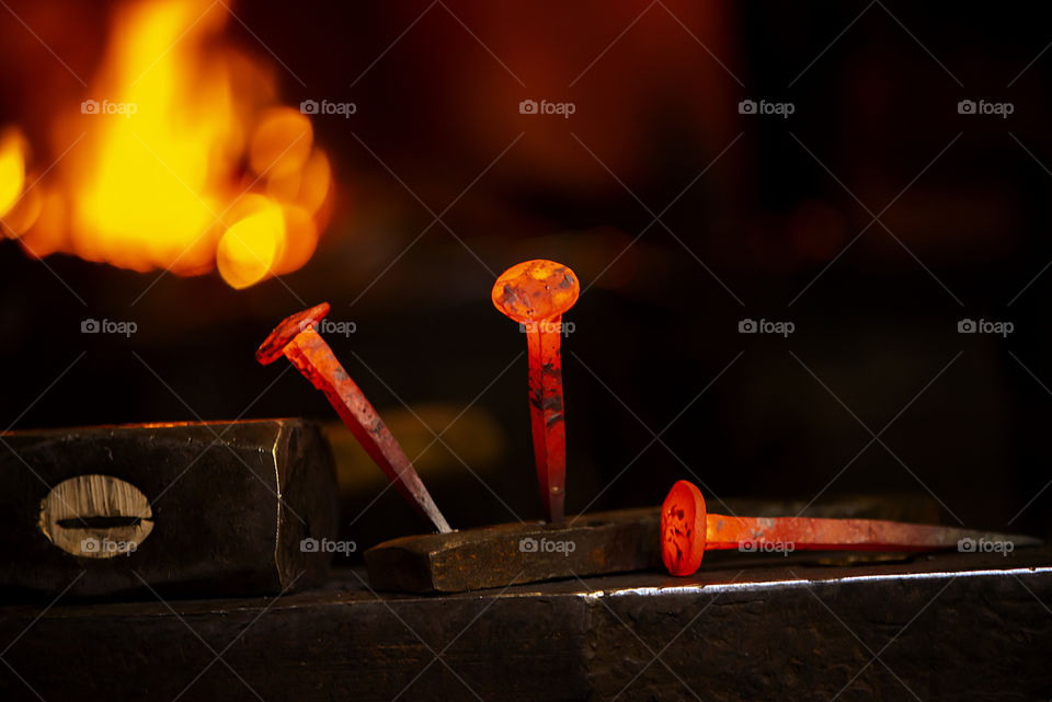 hot metal nail on anvil in blacksmith workshop