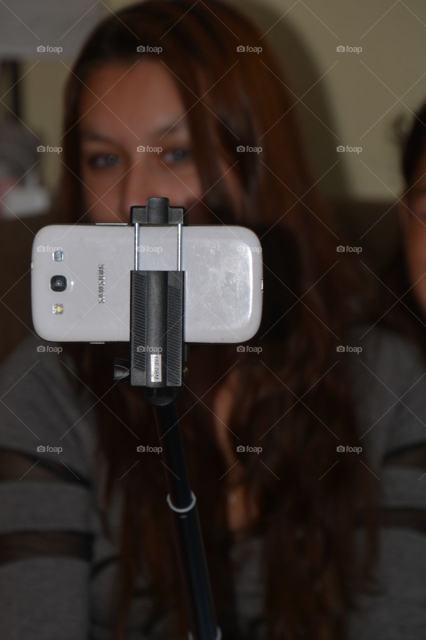 A girl taking a selfie with a selfie stick 