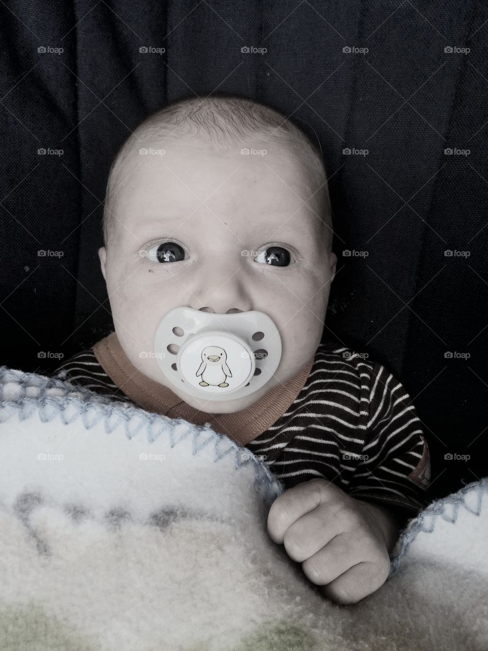 Newborn baby with big eyes and pacifier