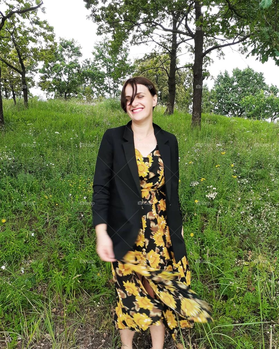 A girl in front of nature in a yellow dress