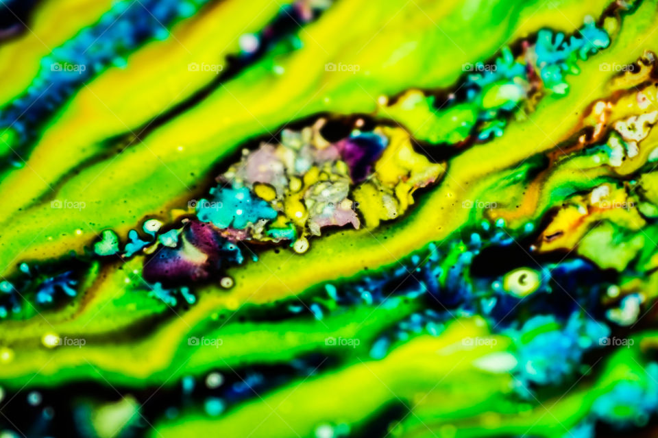 The ink to refill the printer cartridge was spilled onto the white washbasin and the paints blended into abstract drips and patterns.