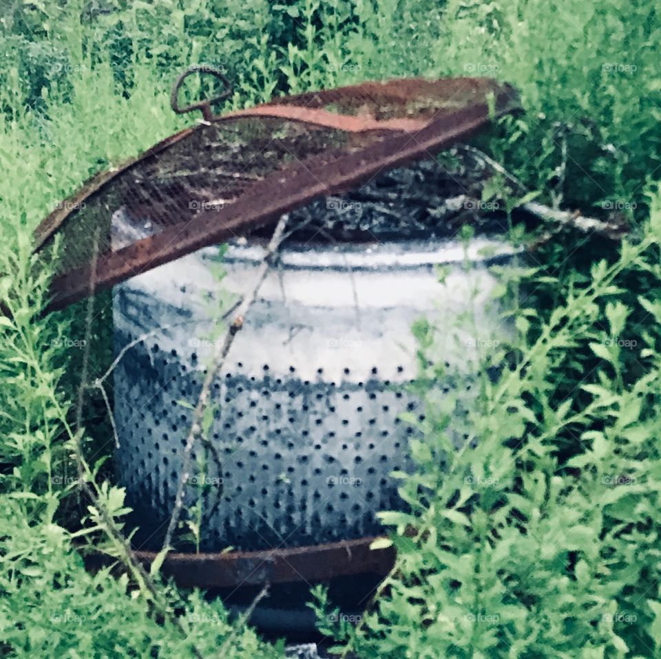 Old washing machine tub fire pit patiently waiting for fall located in the woods of South Georgia. 