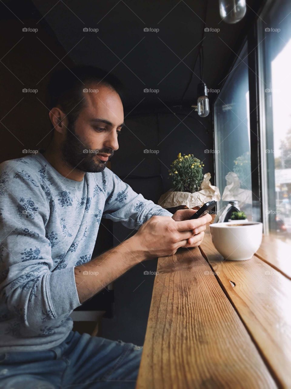 bearded man using mobile at the cafe