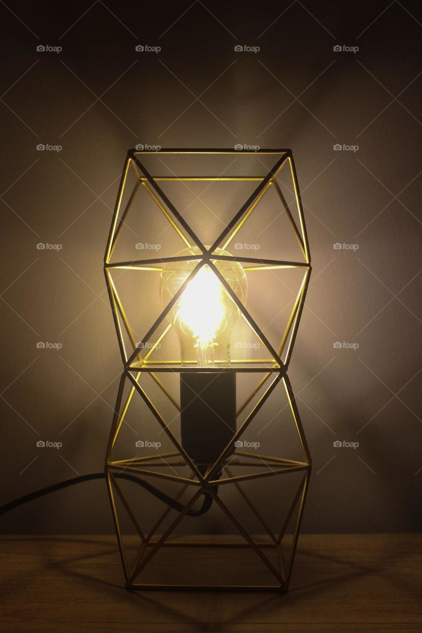 The appearance of a bedroom lamp with a gold color in the form of geometry