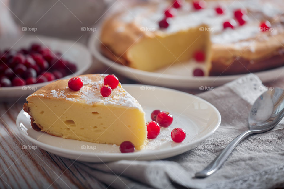 Cheesecake with cranberries and sugar on wooden background