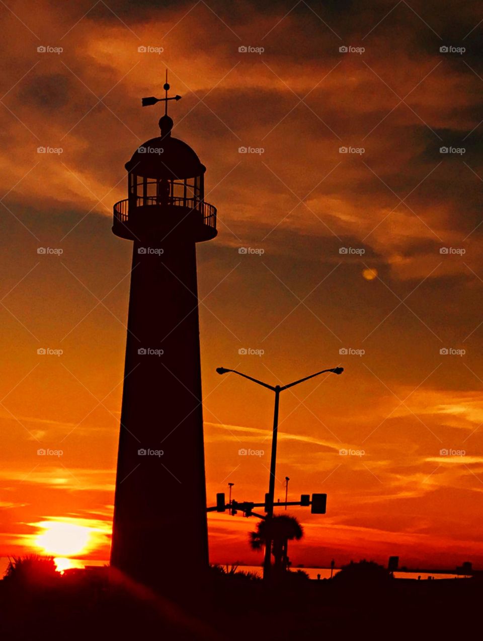 Lighthouse silhouette on a sunset background