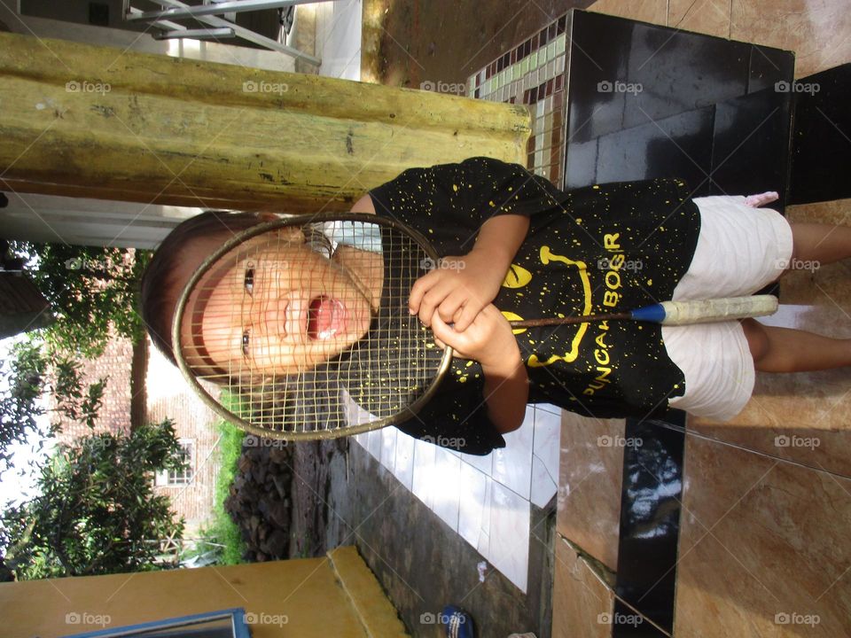 Little girl is playing with a racket