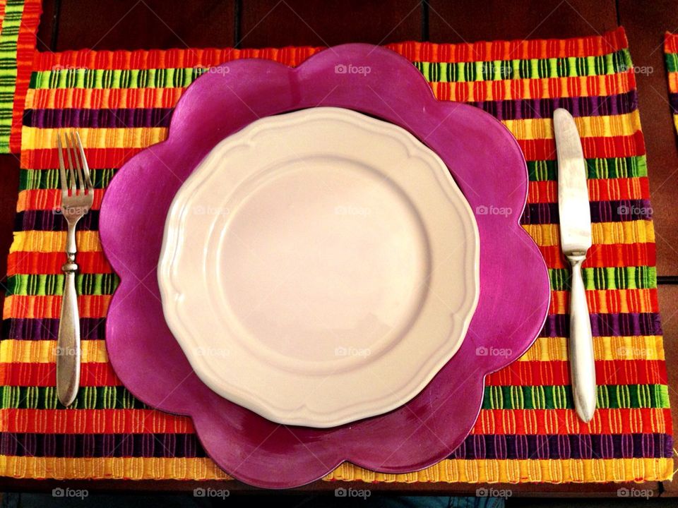 Plate on colorful mat on table