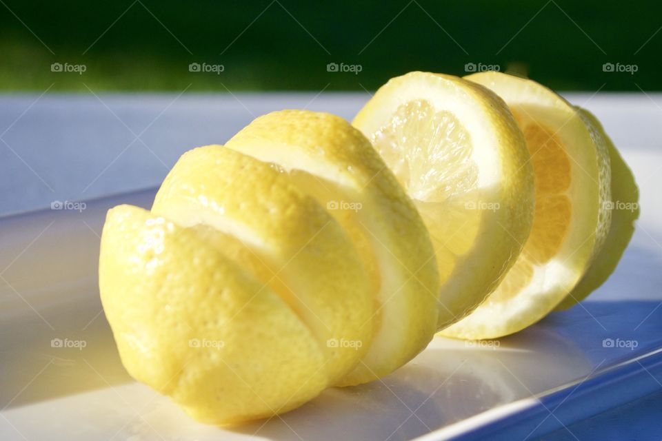 Fruits! - Spiral-cut lemon on a white plate outdoors in sunlight