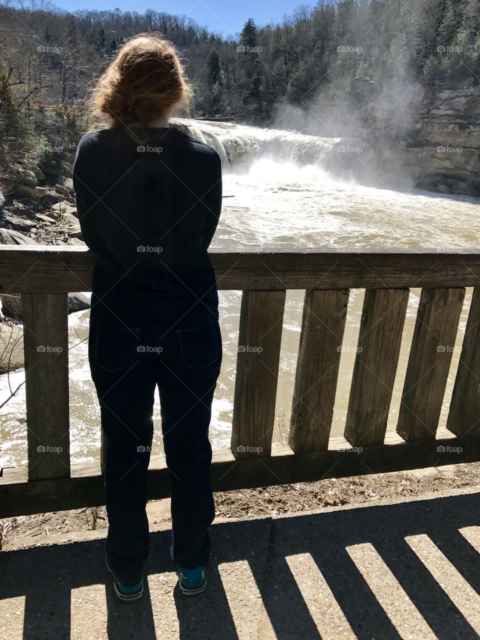 Girl standing at a lookout looking at Cumberland Falls 