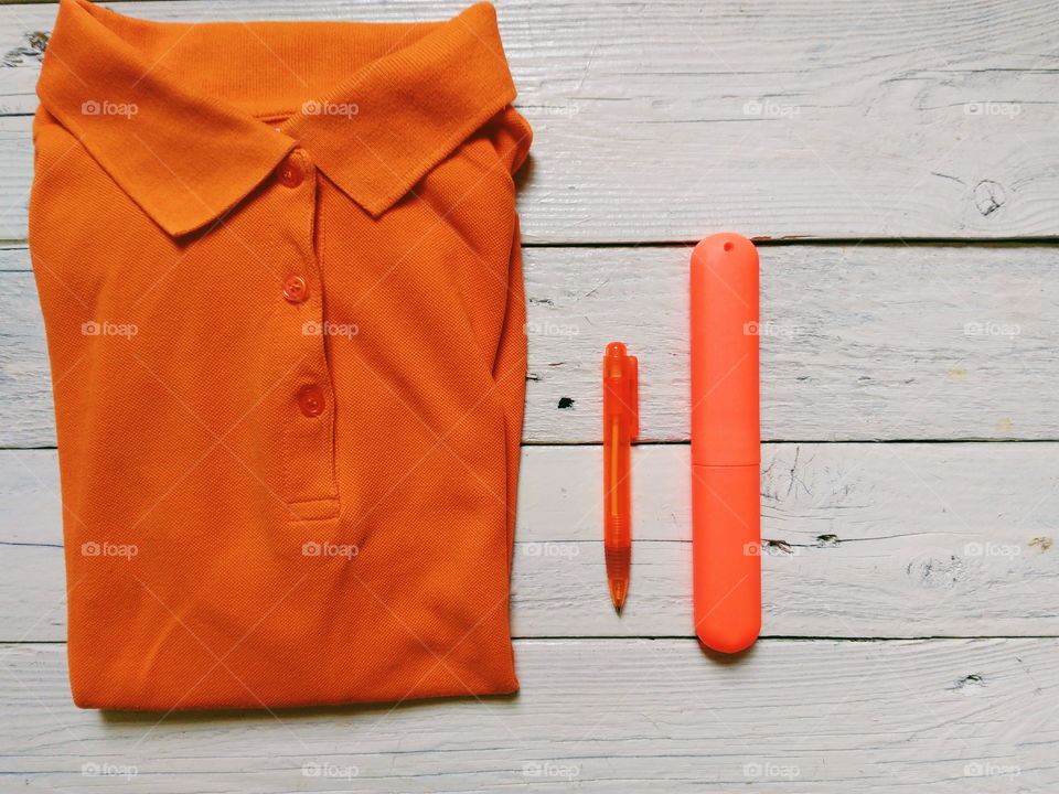 Orange fashionable t-shirt on table