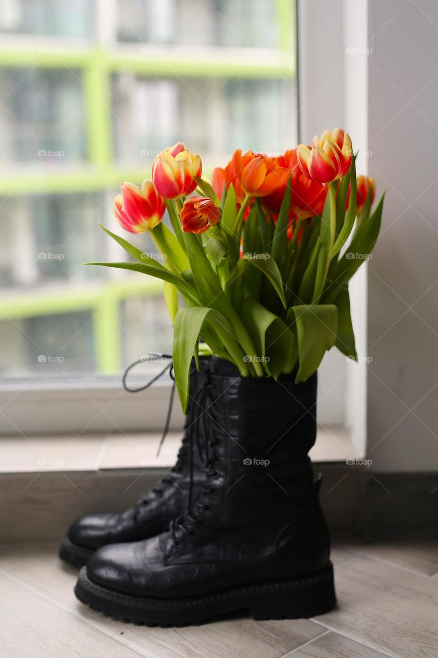 stylish vase for flowers, beautiful tulips in a black vase