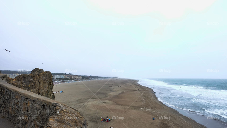 Urban seascape, people at the beach, viewing point on the left